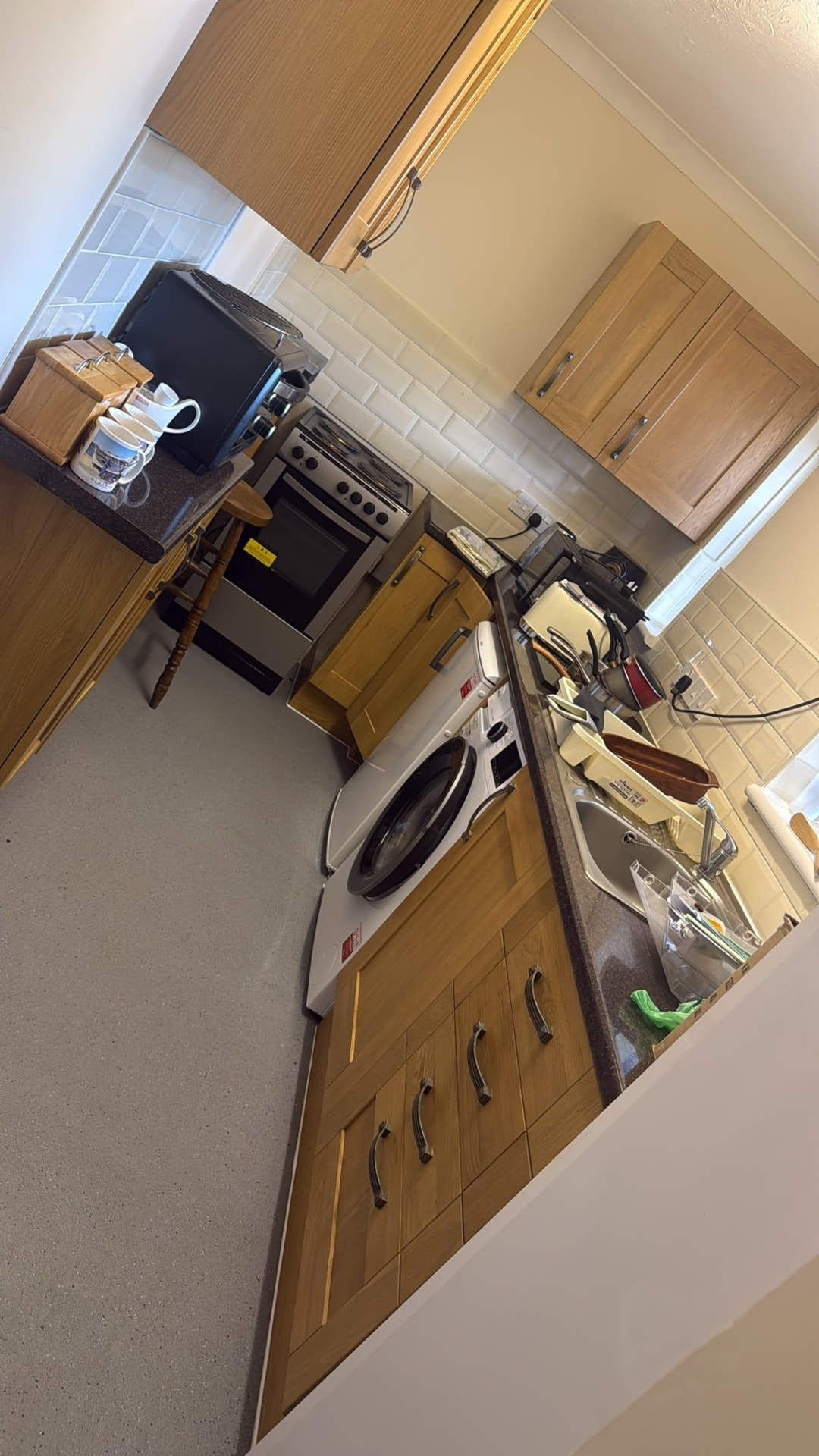 Crowded kitchen with appliances and household items before house clearance in Wimborne, Dorset