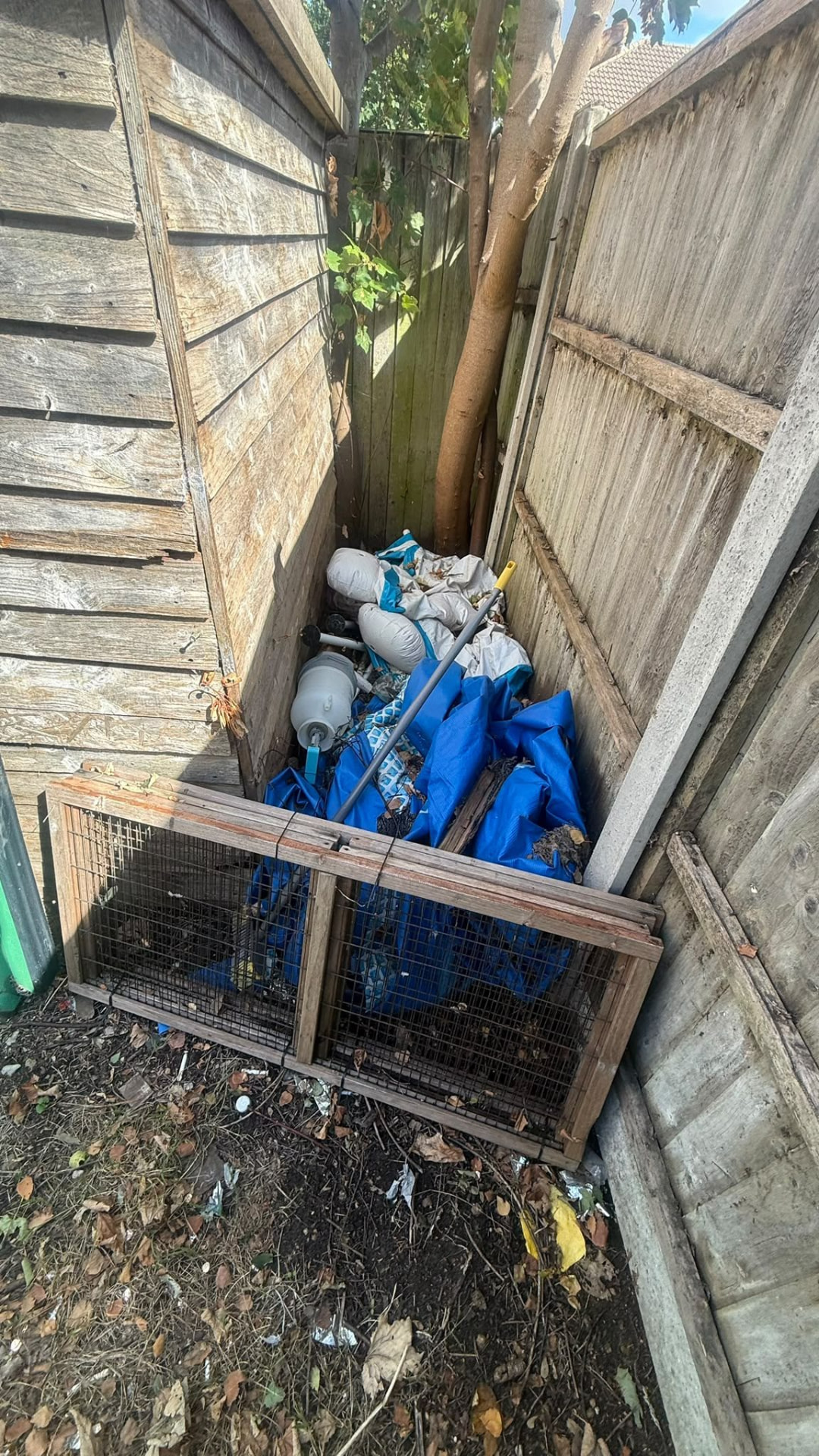 Bags, tarps and waste beside a shed awaiting rubbish removal in Wimborne, Dorset