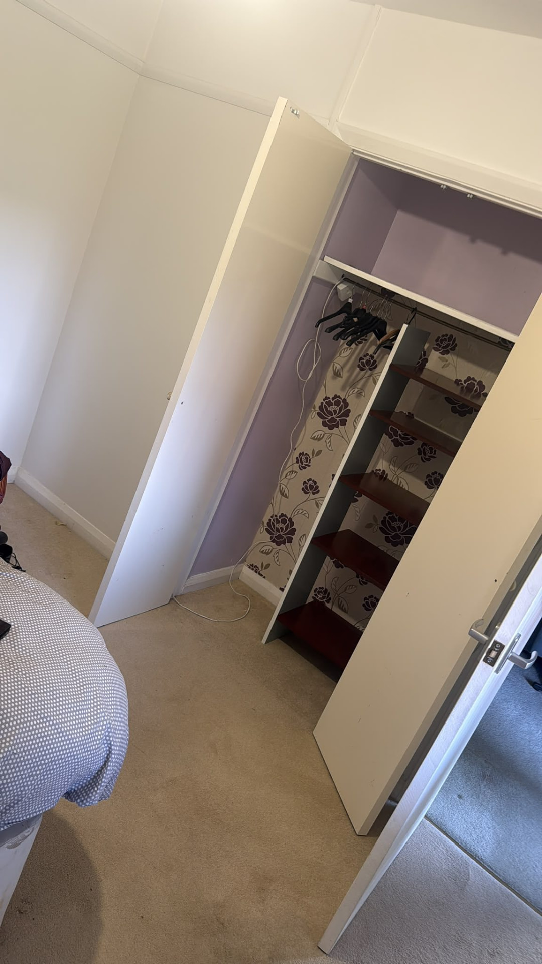 Open wardrobe in a bedroom during a house clearance in Wimborne, Dorset