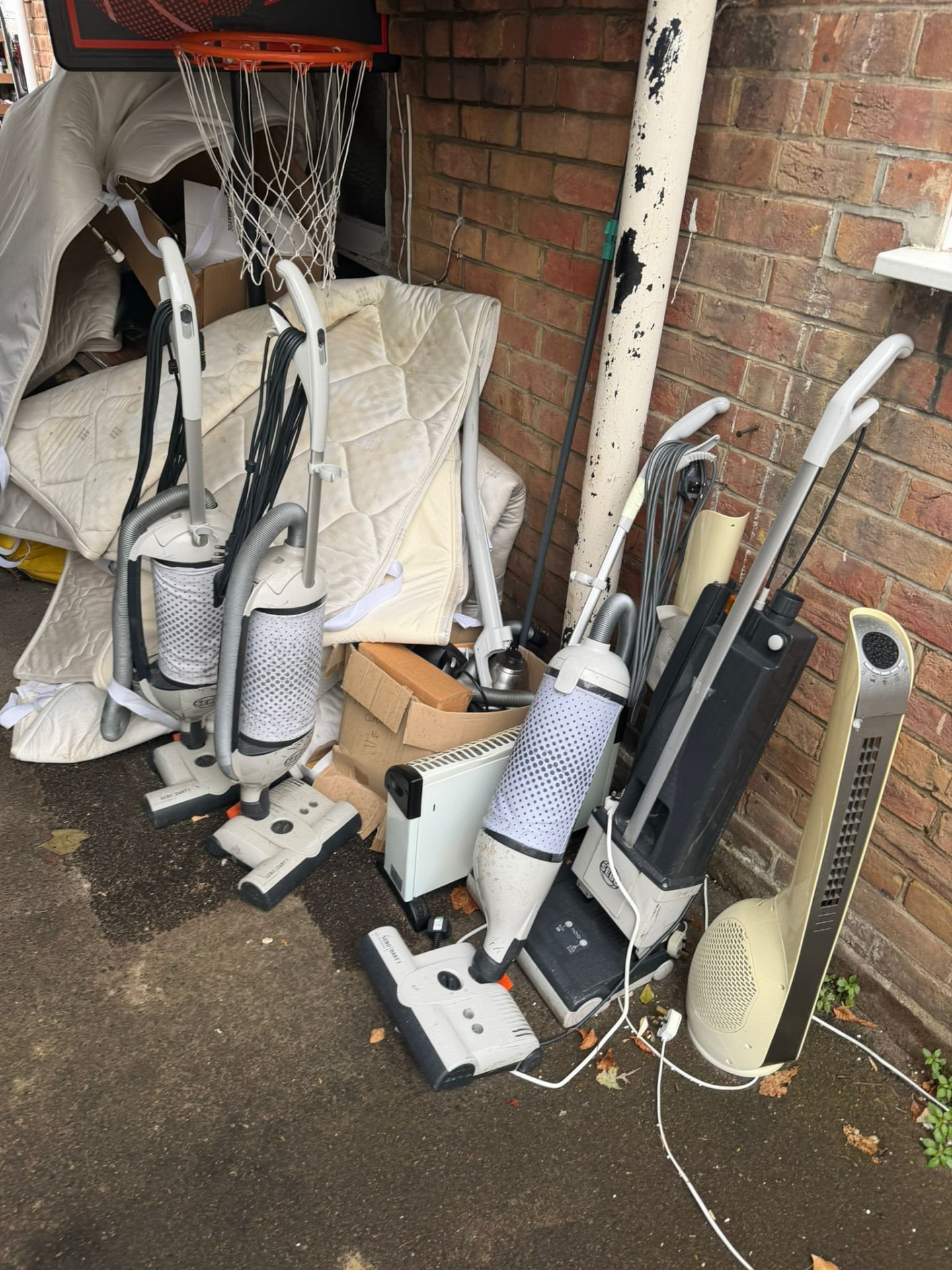 Old vacuum cleaners, a heater and bulky household items awaiting collection in Wimborne, Dorset